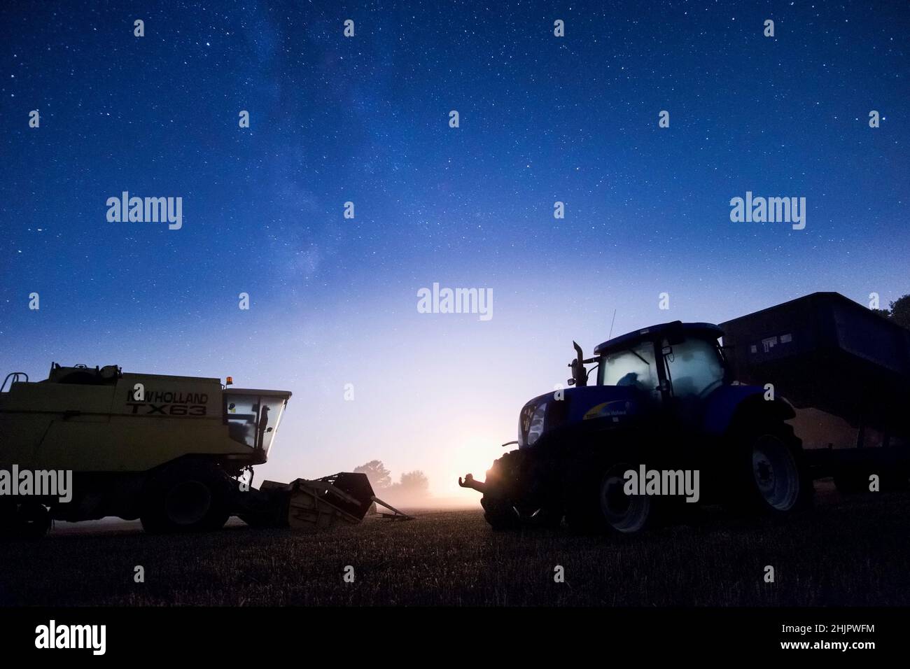 Moissonneuse-batteuse et tracteur de nuit avec ciel étoilé et lune de réglage  Norfolk UK Banque D'Images