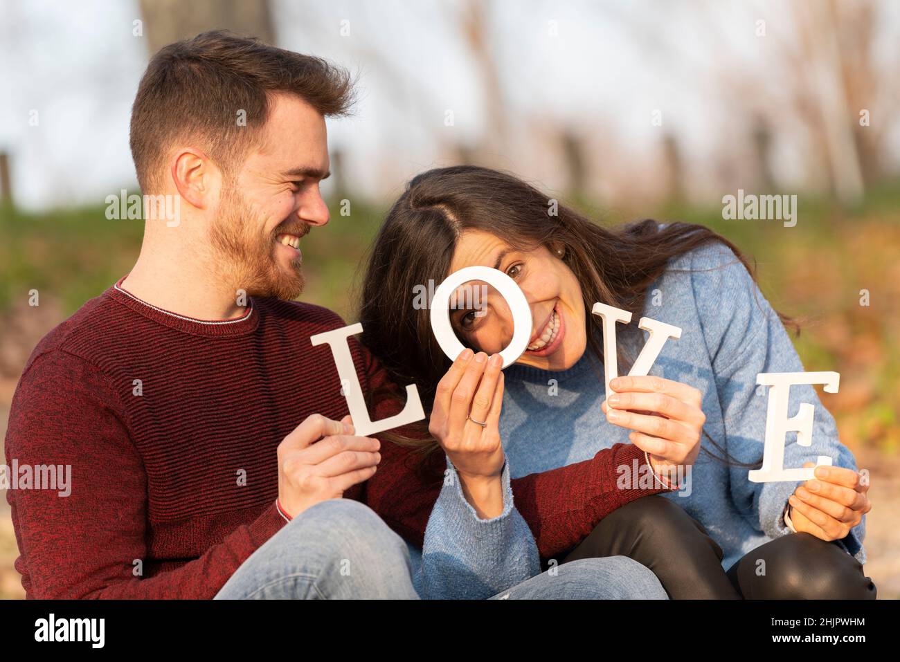 Jeune couple jouant avec des lettres blanches d'amour Banque D'Images