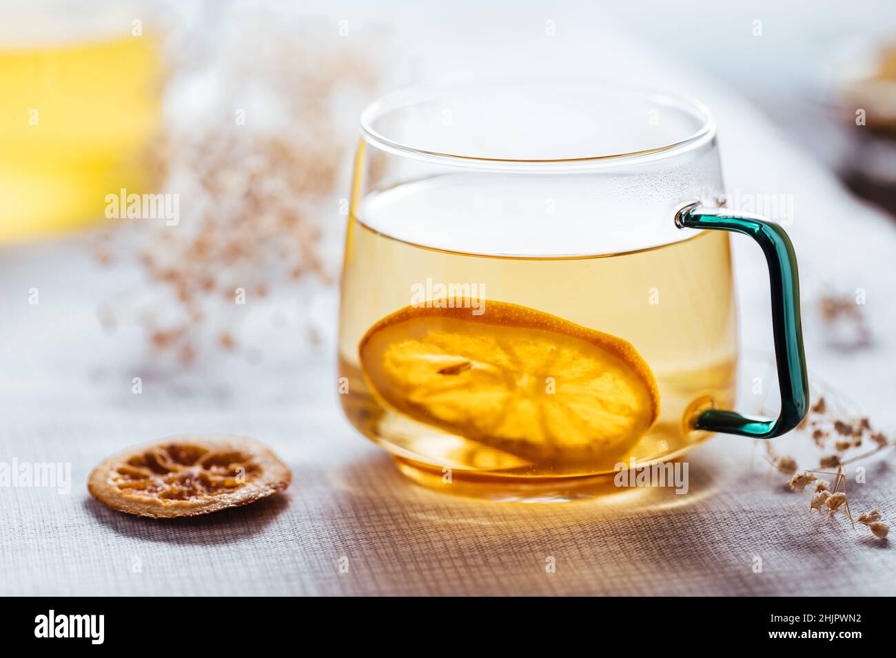 Tasse de thé camomille dans une tasse transparente servie avec une tranche de citron et d'orange.Pause thé. Banque D'Images