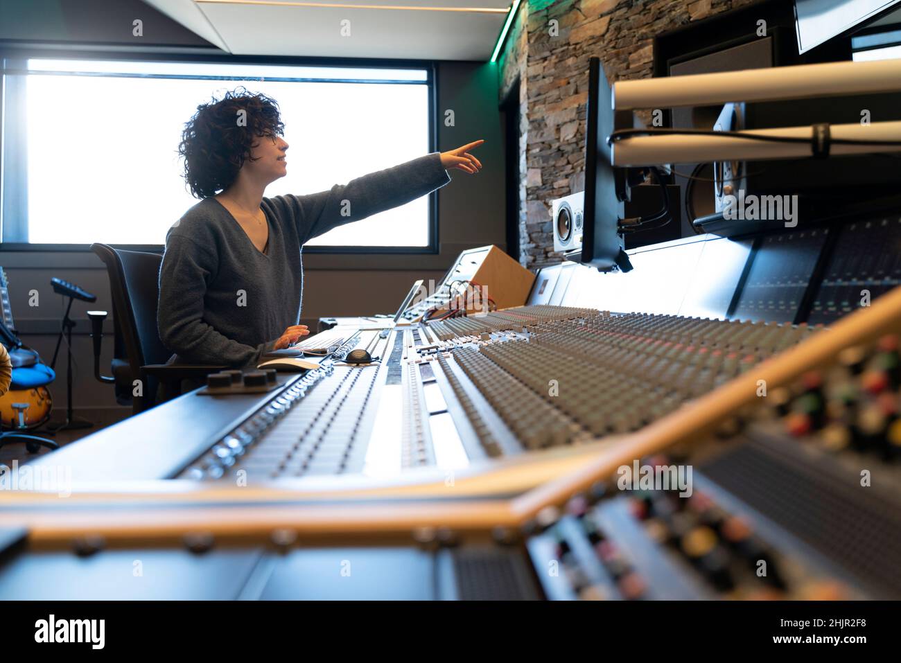 Jeune cheveux bouclés femme caucasienne travaillant dans un studio de musique Banque D'Images