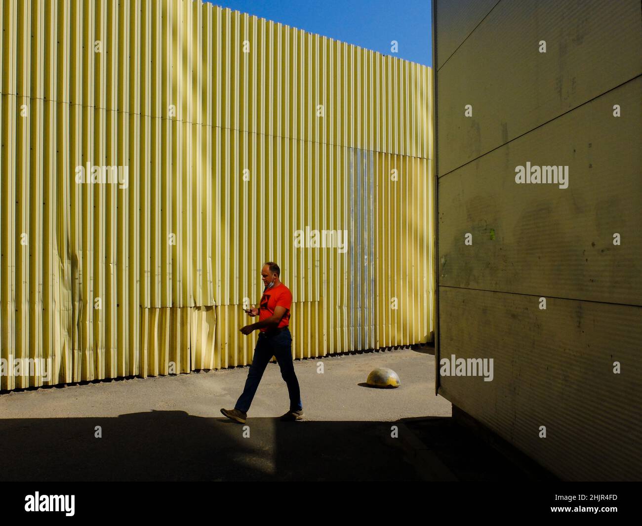 homme dans les rues de marche rouges dans les lumières et les ombres Banque D'Images