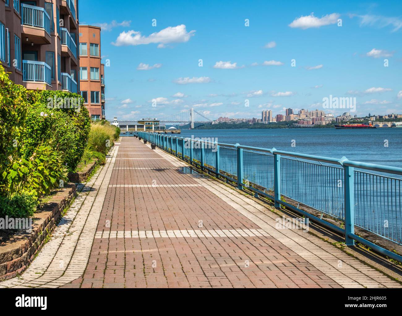 Sentier de promenade sur la rivière à Edgewater, New Jersey, États-Unis, en direction de NY City et du pont George Washington, avec un ciel bleu clair. Banque D'Images