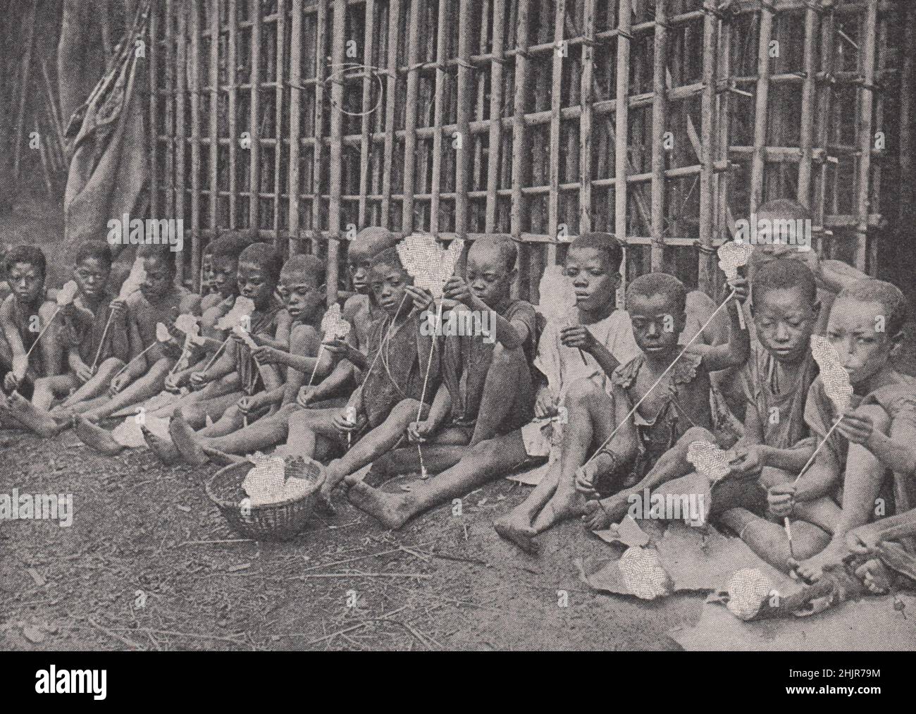 Les enfants apprennent à faire tourner le coton au Cameroun français. Afrique de l'Ouest (carte 1923) Banque D'Images