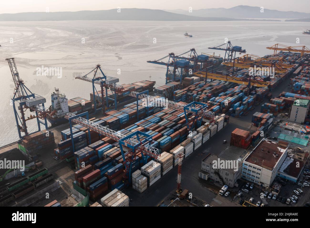 Vladivostok, Russie - 26 janvier 2022 : Vue de dessus du terminal des conteneurs du port maritime.En hiver, un bateau à conteneurs est en train de charger à l'embarcadère. Banque D'Images