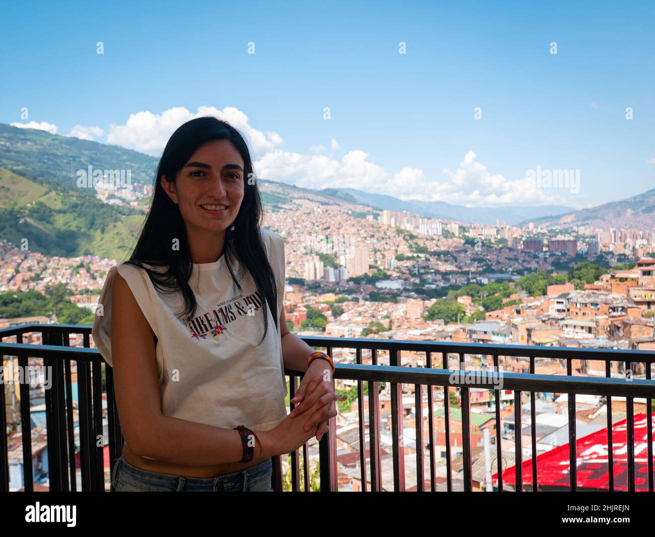 La femme à cheveux noirs regarde la caméra et pose avec le fond de la ville de Medellin, en Colombie Banque D'Images