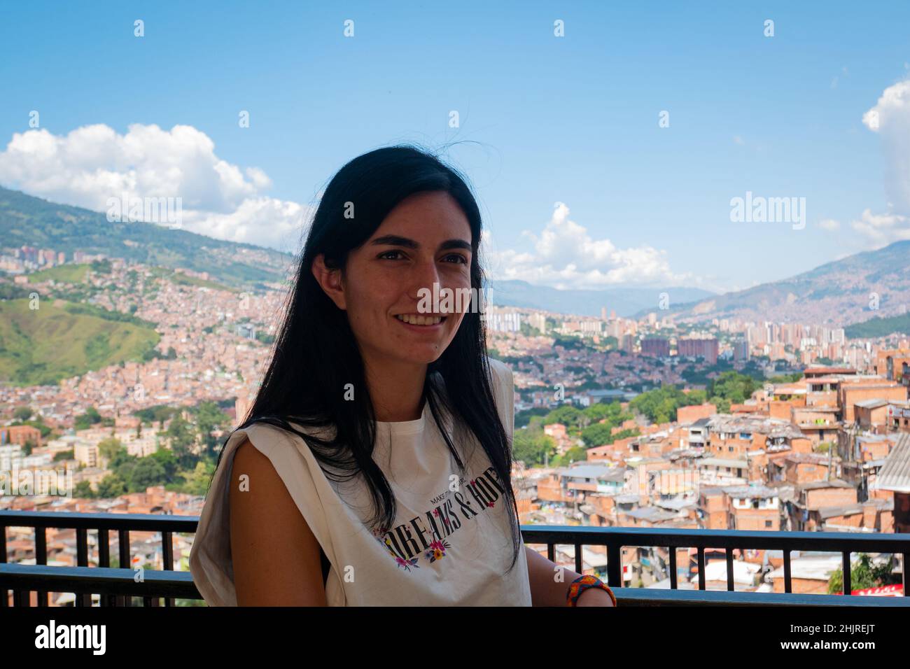 La femme à cheveux noirs regarde la caméra et pose avec le fond de la ville de Medellin, en Colombie Banque D'Images