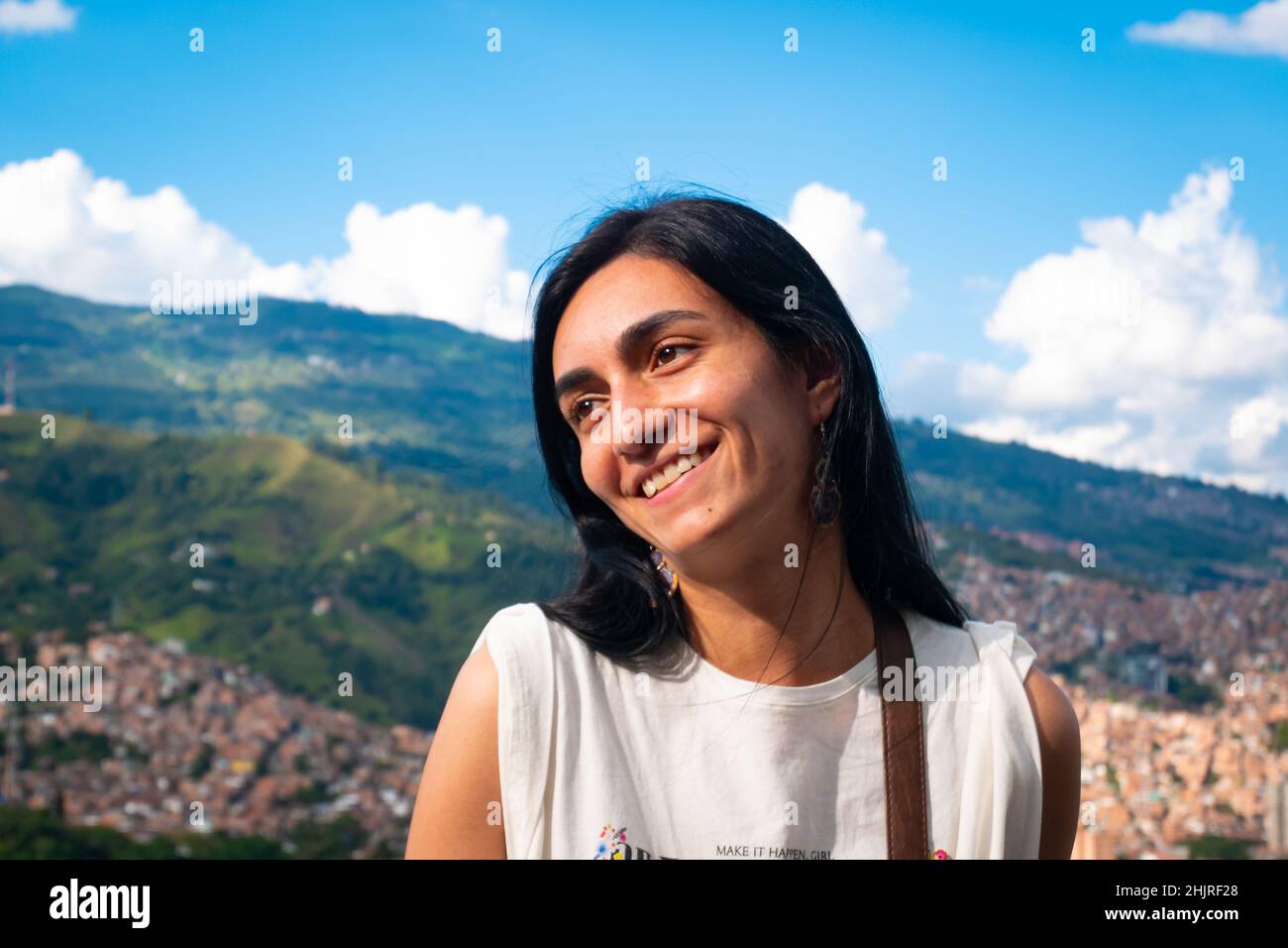 La femme aux cheveux noirs pose avec le fond de la ville de Medellin, en Colombie Banque D'Images