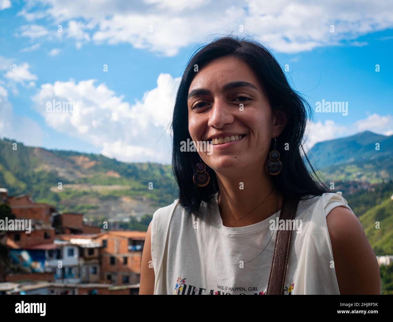 La femme à cheveux noirs regarde la caméra et pose avec le fond de la ville de Medellin, en Colombie Banque D'Images