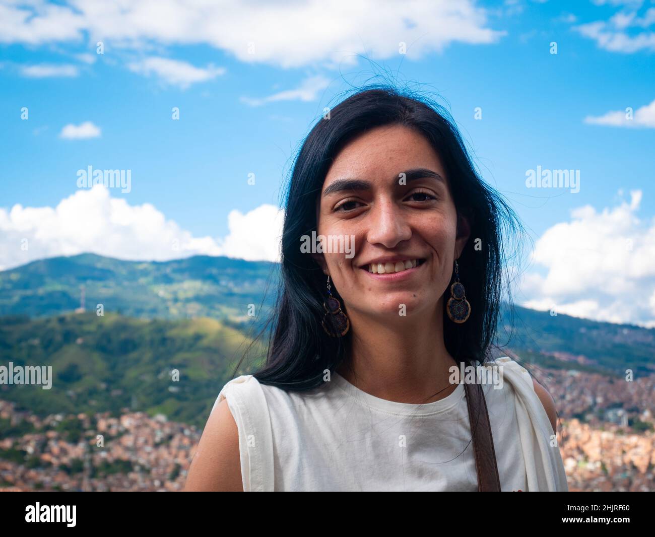 La femme à cheveux noirs regarde la caméra et pose avec le fond de la ville de Medellin, en Colombie Banque D'Images