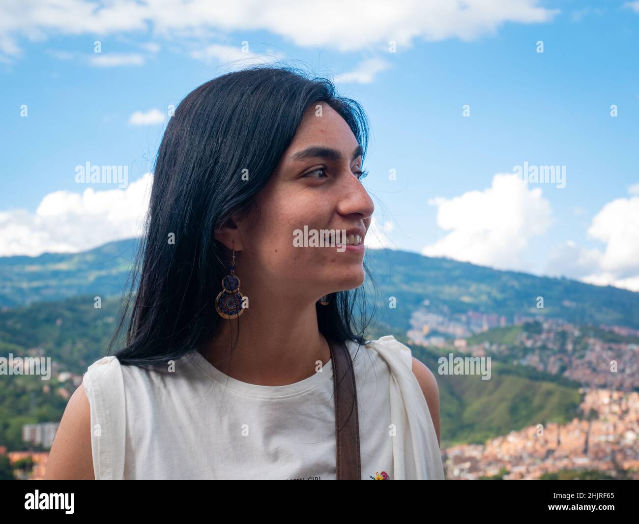 La femme aux cheveux noirs pose avec le fond de la ville de Medellin, en Colombie Banque D'Images