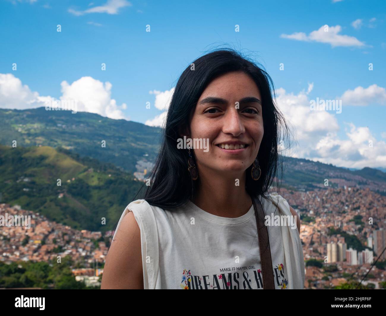 La femme à cheveux noirs regarde la caméra et pose avec le fond de la ville de Medellin, en Colombie Banque D'Images