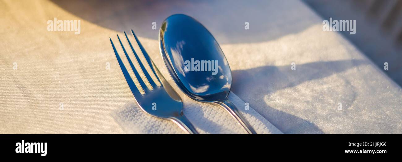 Fourchette et cuillère avec réflexion de nuages.Dîner dans la BANNIÈRE concept en plein air, FORMAT LONG Banque D'Images