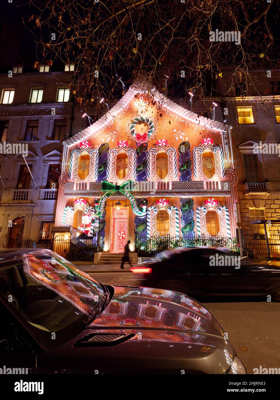 Londres, Grand Londres, Angleterre, janvier 4th 2022 : l'homme marche à côté du club privé Anabels avec sa façade de Noël Gingerbread House à Berkeley Square. Banque D'Images
