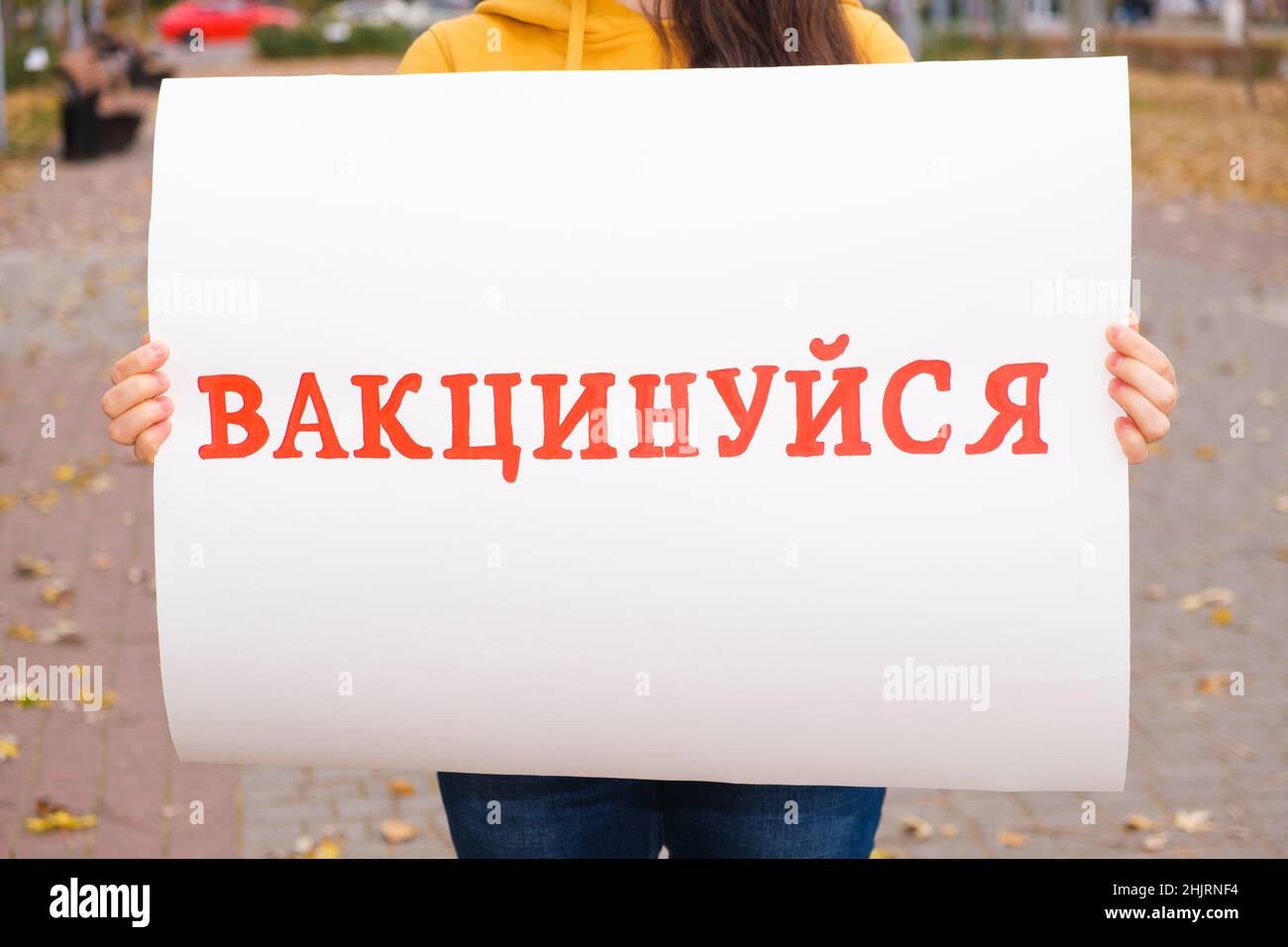 Une femme possède une affiche avec du texte, traduit de l'ukrainien: Se faire vacciner Banque D'Images