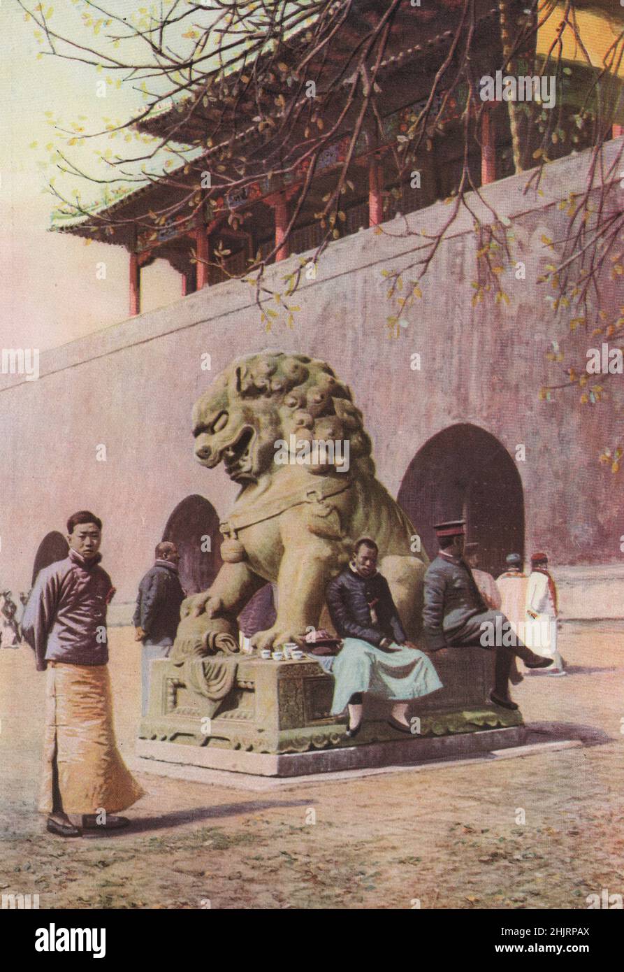 Un lion de bronze, symbole chinois du courage et de la générosité, abonne ses fangs à l'entrée de l'ancien Palais impérial. Chine. Pékin (1923) Banque D'Images