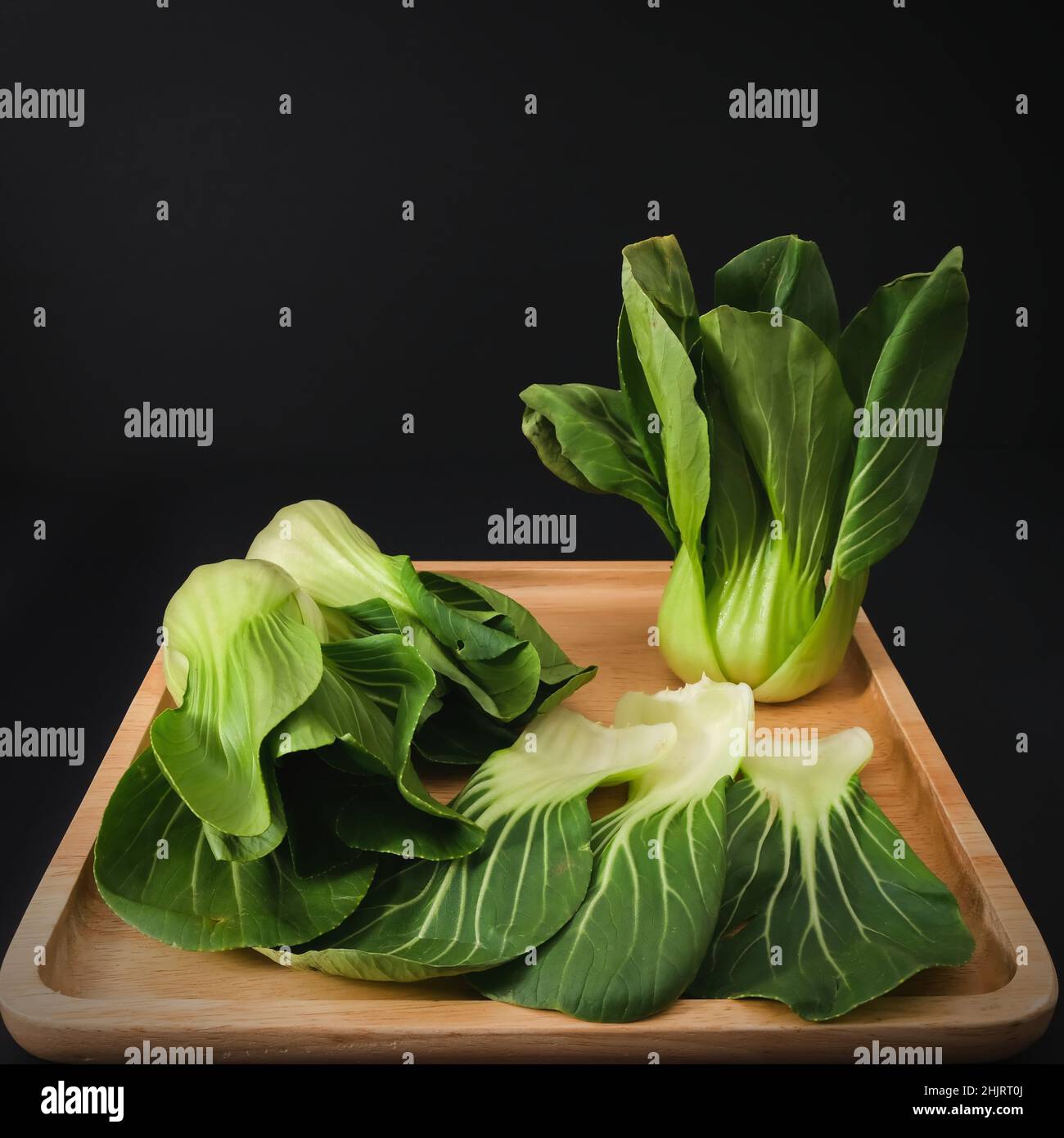 Vert biologique Baby Bok Choy ou Brassica rapa chinensis sur plaque en bois sur fond noir.Légumes chinois populaires Banque D'Images