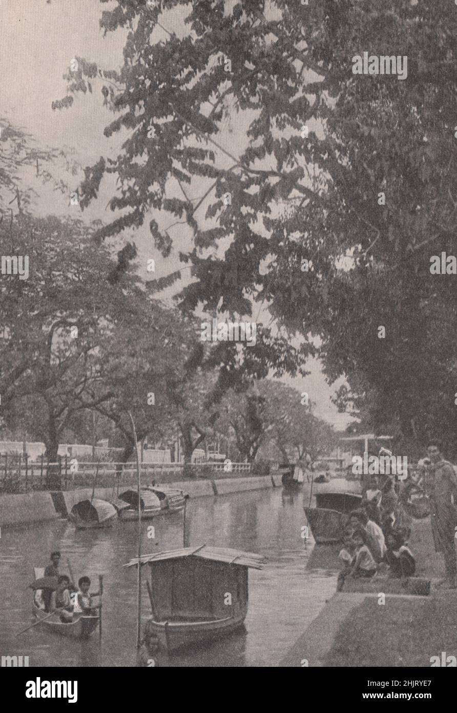 Canal moderne bordé de riches feuillages dans la capitale. Thaïlande. Siam (1923) Banque D'Images