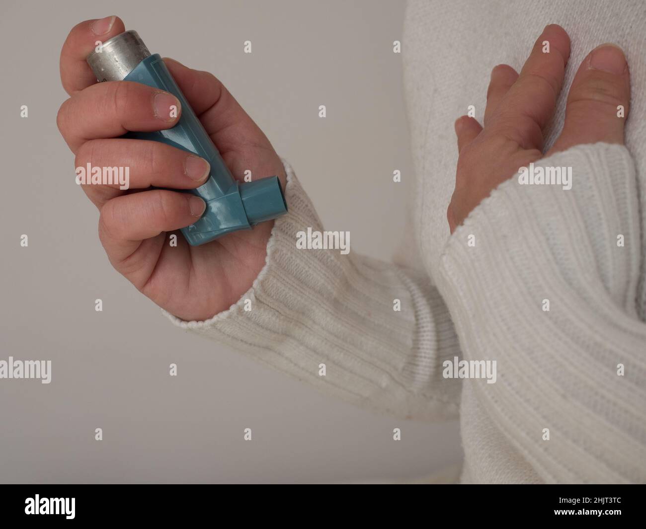 femme d'âge moyen utilisant un inhalateur bleu d'asthme pour soulager une crise d'asthme.Le produit pharmaceutique est utilisé pour prévenir et traiter la respiration sifflante et le shortn Banque D'Images