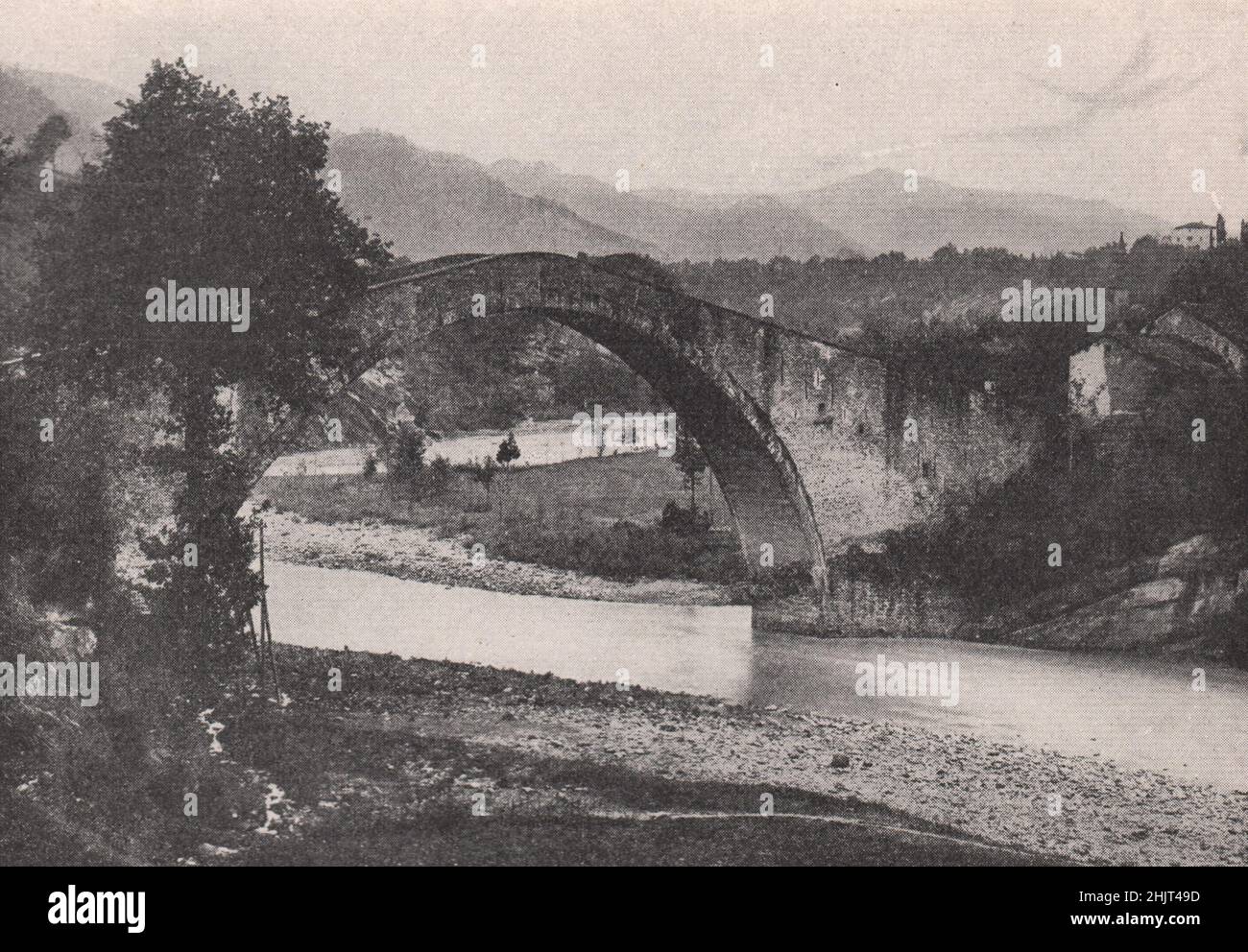 Un ruisseau Apennine encadré dans l'arche d'un vieux pont. Italie. Toscane (1923) Banque D'Images