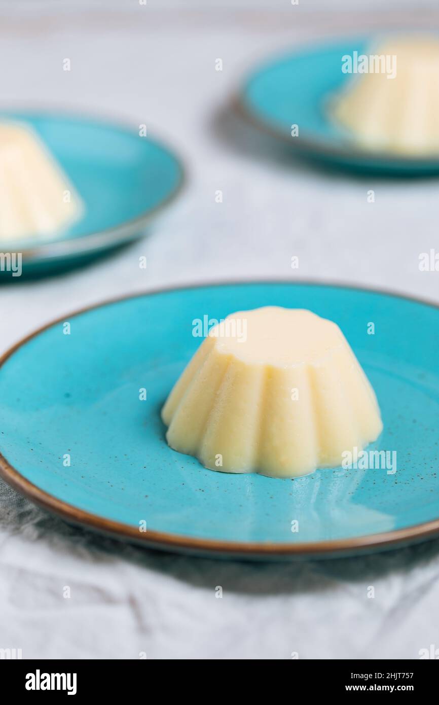 Pudding à la vanille sur une assiette en porcelaine bleue avec chapelure au  chocolat sur le dessus.Arrière-plan lumineux Photo Stock - Alamy