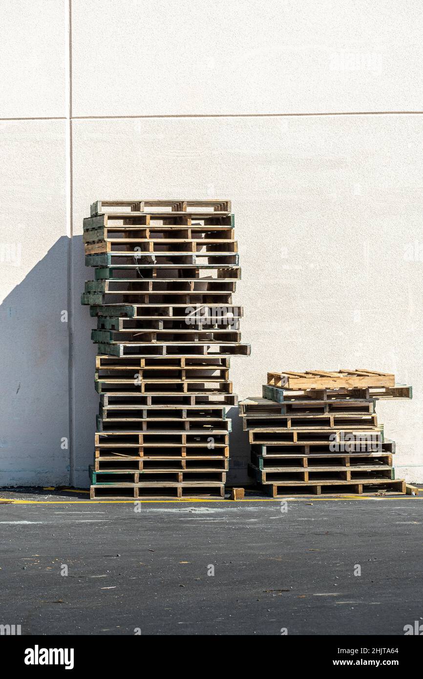 Plan vertical d'une pile de palettes en bois vides contre un mur. Banque D'Images