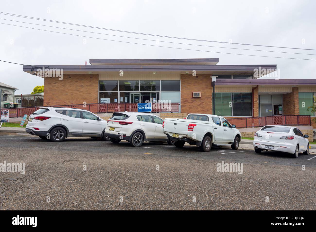 Une rangée de voitures blanches est garée à l'extérieur du bâtiment moderne du conseil local du milieu du siècle à Gloucester, Nouvelle-Galles du Sud, en Australie Banque D'Images