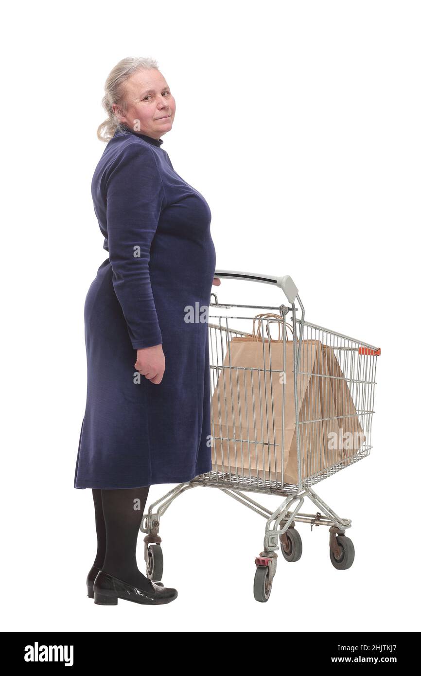 Vue arrière d'une femme âgée qui fait du shopping au supermarché et qui pousse un chariot. Banque D'Images