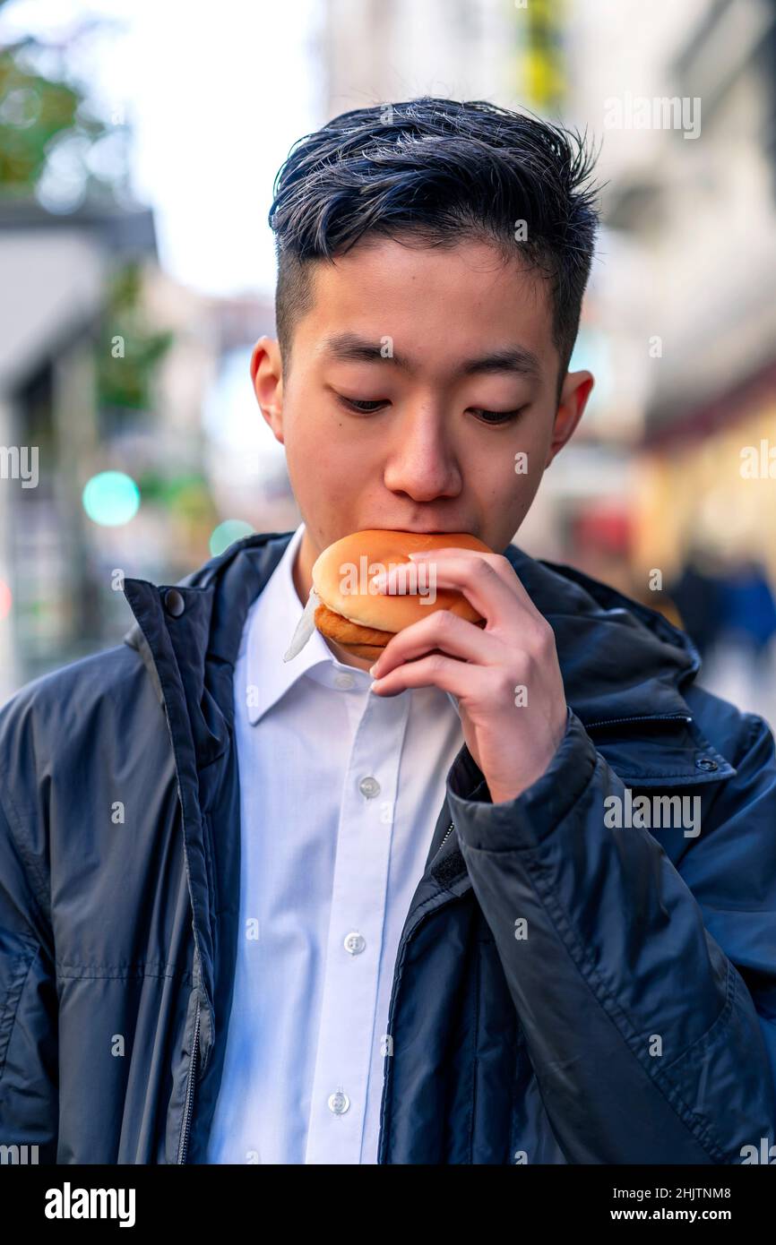 Japonais manger un délicieux hamburger Banque D'Images