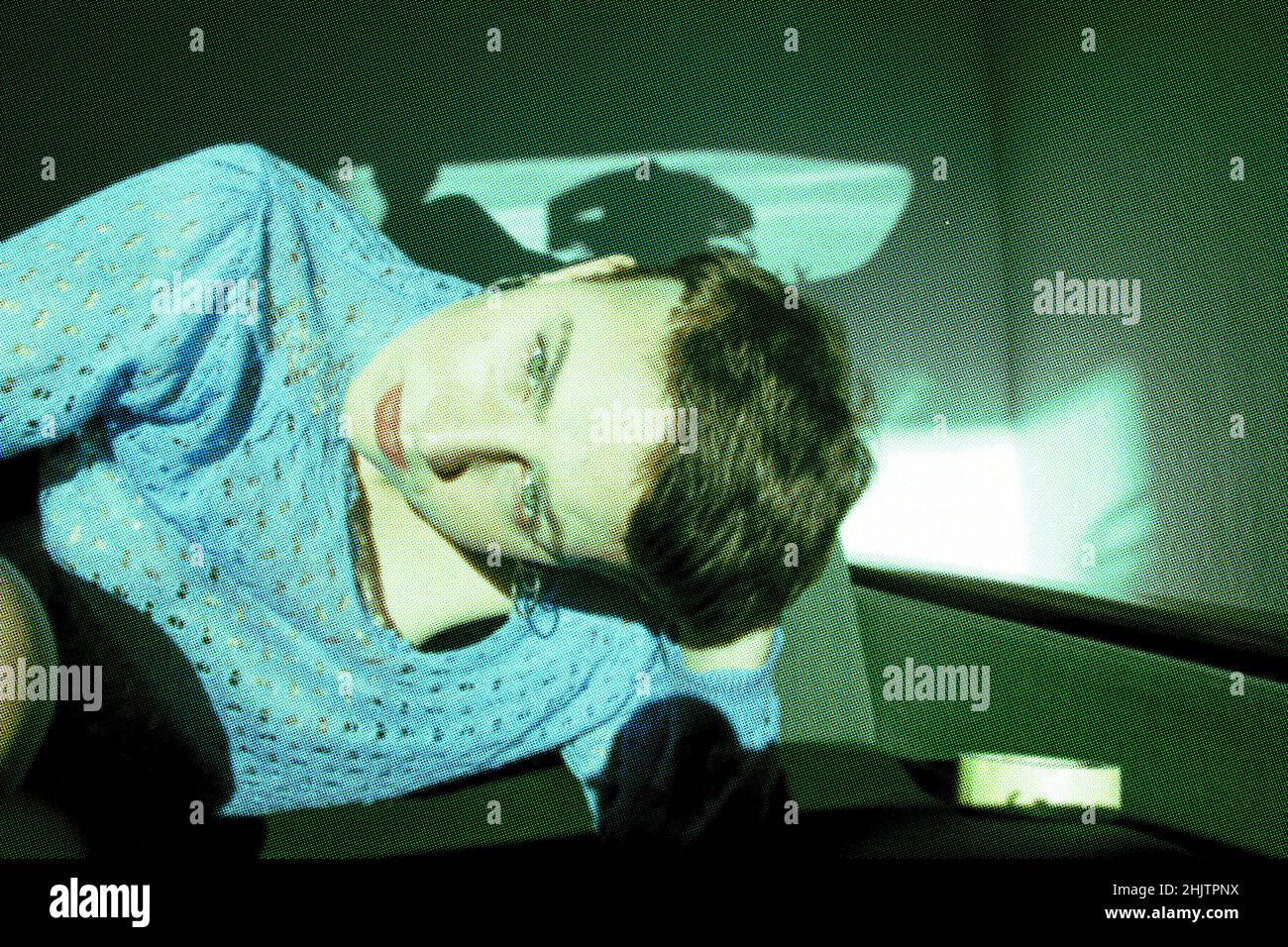 une jeune femme se trouve sur le canapé et semble intéressée par le venu Banque D'Images