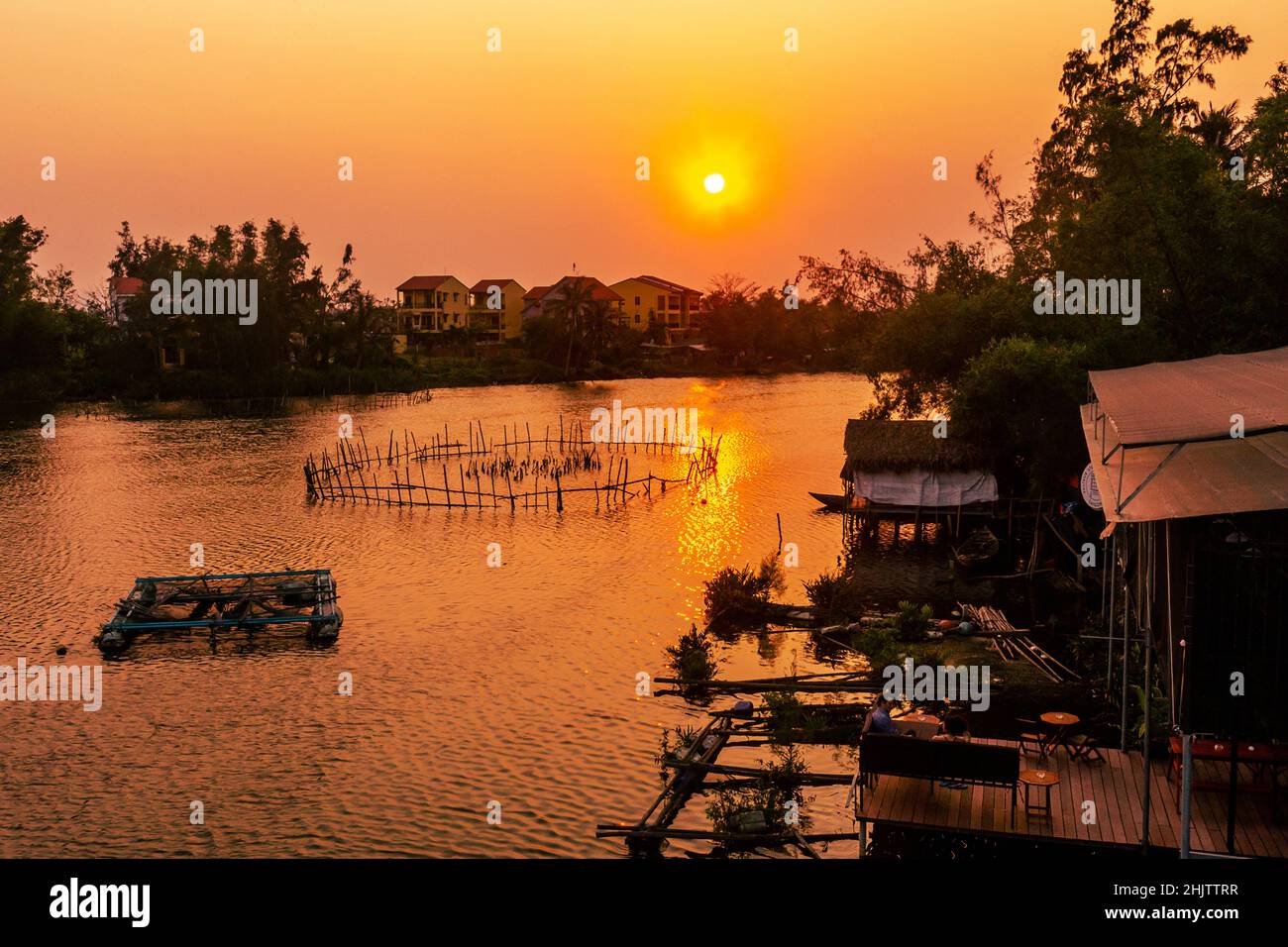 La rivière Thu bon s'écoule vers la mer non loin de cette image panoramique au coucher du soleil à Hoi an. Banque D'Images