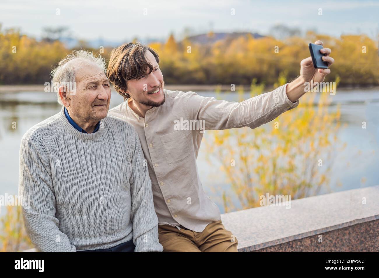 Un homme prend un selfie avec un homme plus âgé Banque D'Images