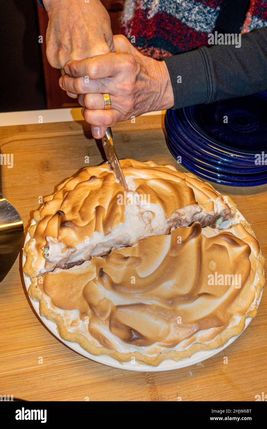 Femme qui coupe et sert un dessert Alaska cuit au four.St Paul Minnesota MN États-Unis Banque D'Images