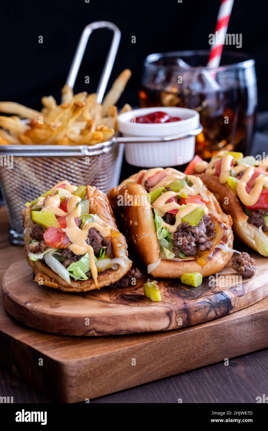 Cheeseburger tacos avec frites et cola sur fond noir. Banque D'Images