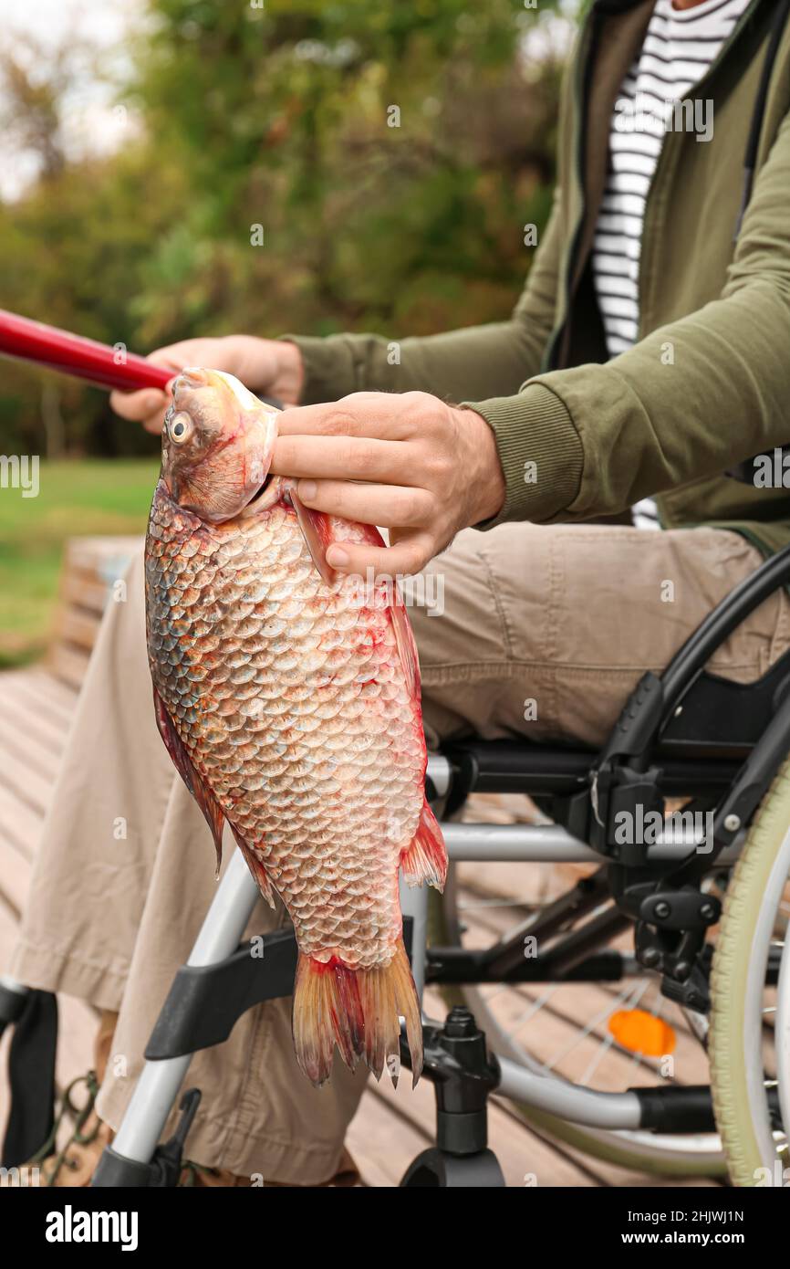 Homme en fauteuil roulant, pêche sur la rivière Banque D'Images