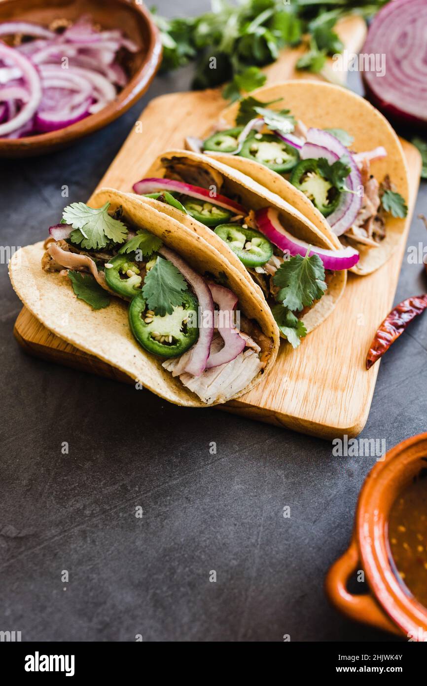 des tacos de rue mexicains avec des carnitas de porc, des tortillas, de l'avocat, de l'oignon, de la coriandre dans la ville de Mexico Banque D'Images