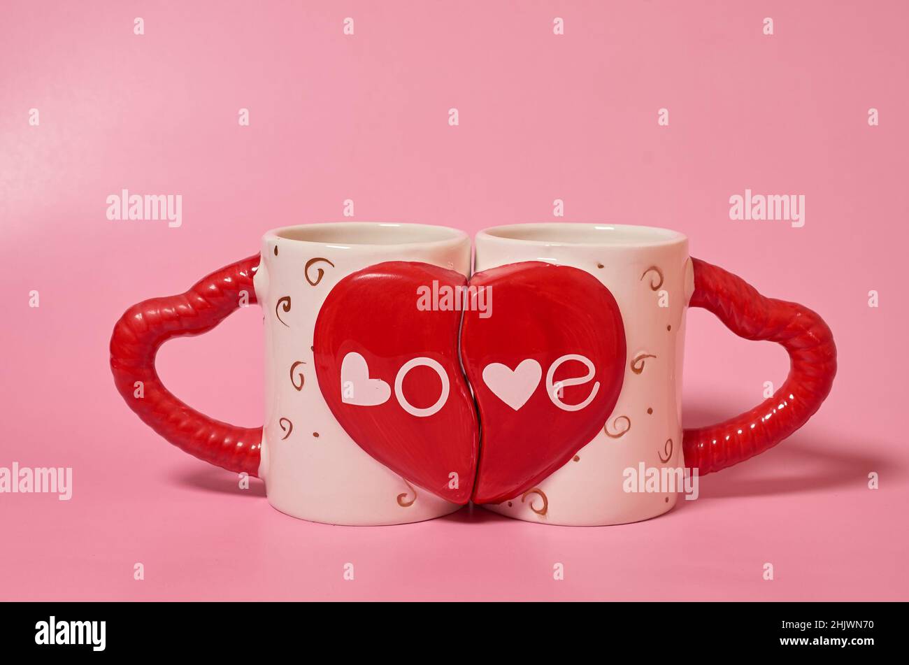 Deux mugs appariés avec l'inscription Amour et poignées sous forme de coeurs Banque D'Images