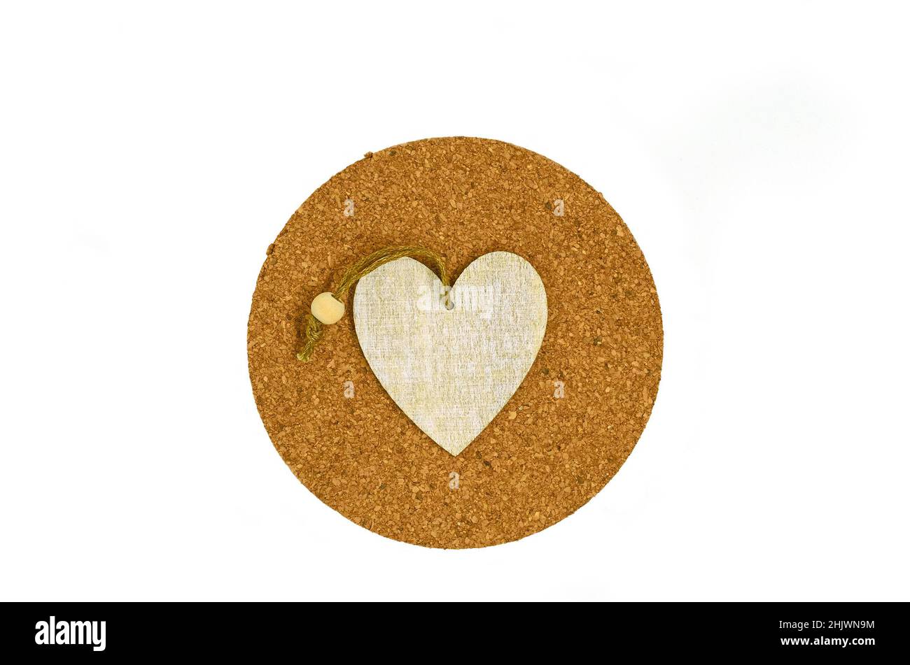 Une suspension en bois sous forme de coeur se trouve sur un support en liège rond pour chaud Banque D'Images