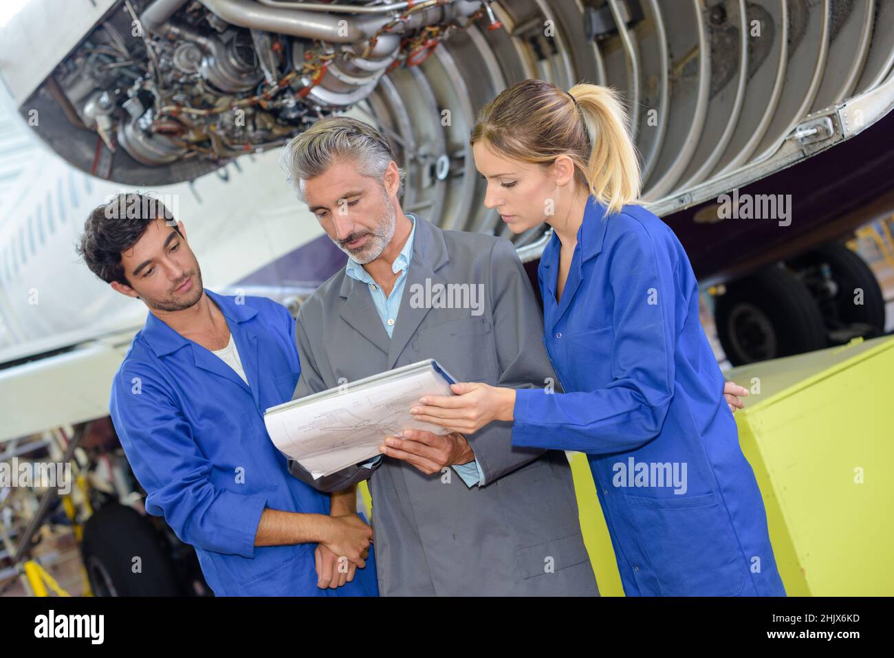 étudiants en aérospatiale avec professeur dans le hangar d'avion Banque D'Images