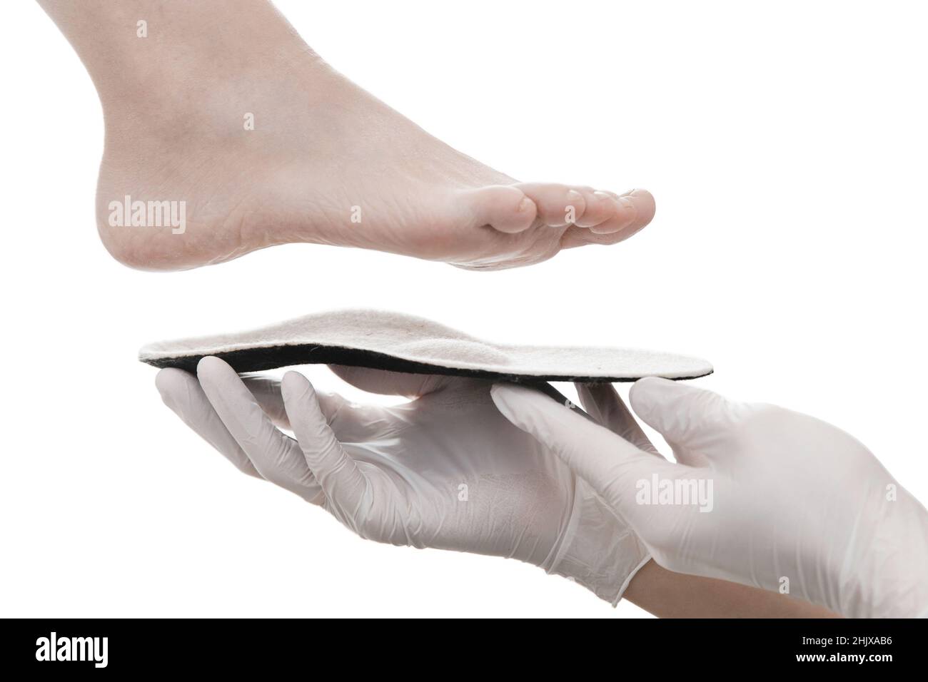 Semelle intérieure orthopédique isolée sur fond blanc.Les mains dans des  gants en caoutchouc tiennent une semelle intérieure orthopédique.Soins des  pieds, confort pour les pieds.Médecin Photo Stock - Alamy