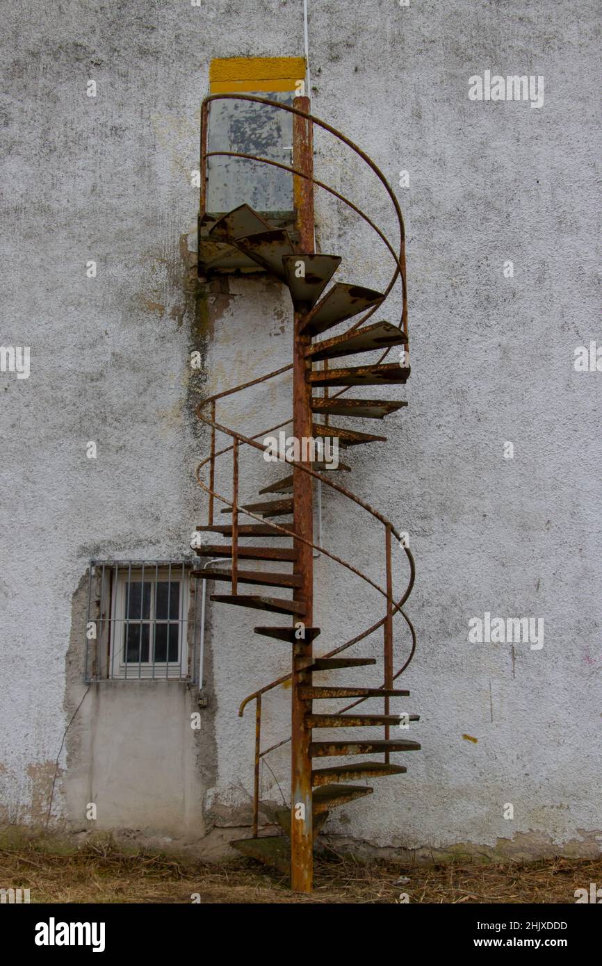 Vieux escalier en colimaçon rouillé menant à une porte fermée à l'extérieur d'un vieux bâtiment Banque D'Images