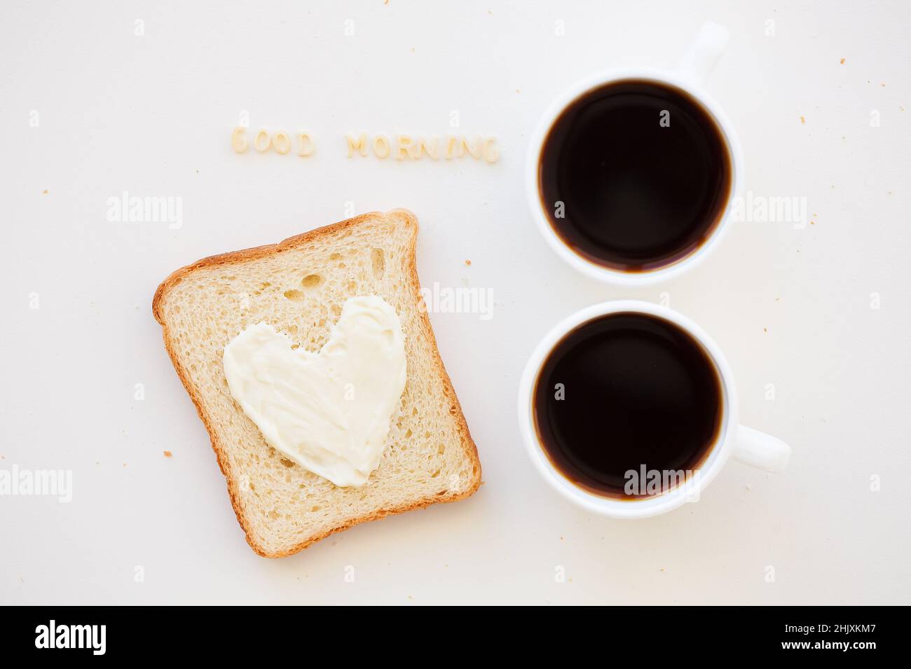 sandwich pour le petit déjeuner sous forme de coeur avec fromage - bon signe du matin et deux tasses de café Banque D'Images