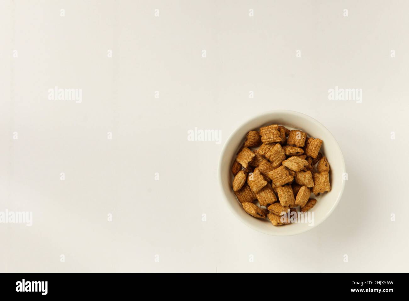 bol avec muesli sur fond blanc. délicieux petit déjeuner avec flocons servi dans un bol en céramique blanche Banque D'Images