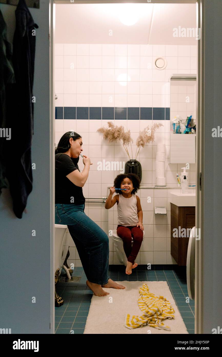 Mère et fille se brossant les dents ensemble dans la salle de bains à la maison Banque D'Images
