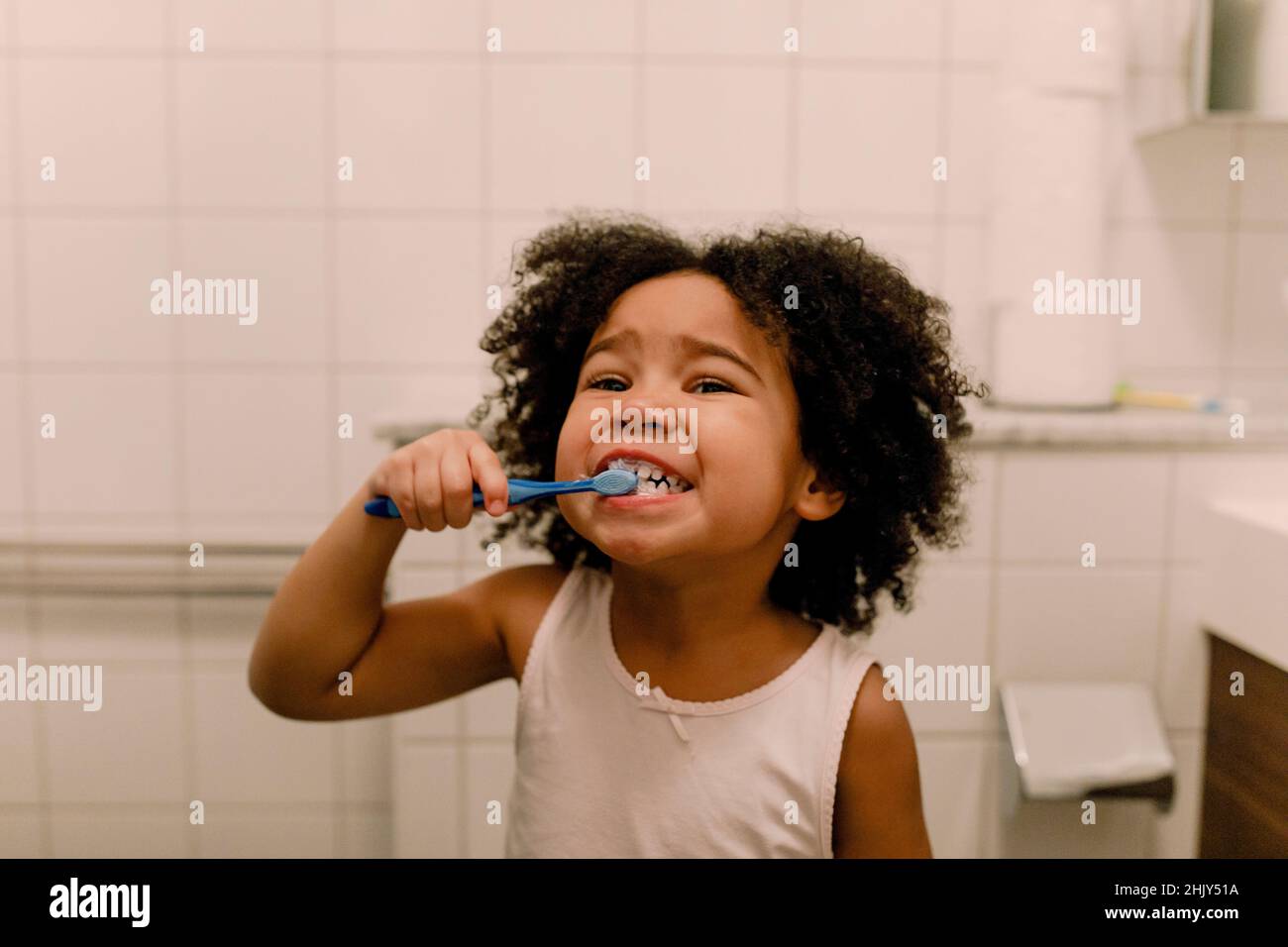 Jeune fille se brosser les dents dans la salle de bains Banque D'Images