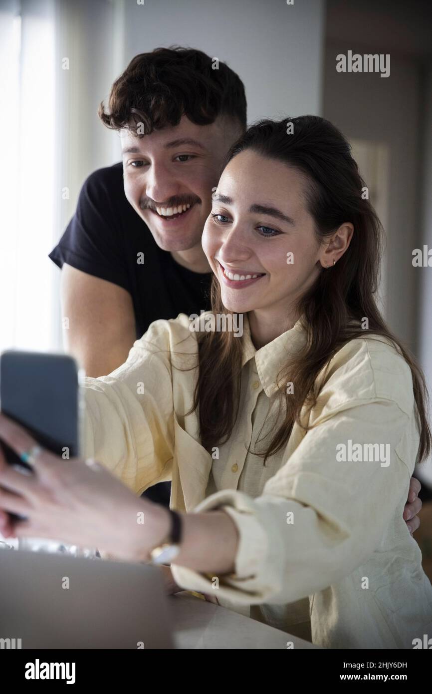 Couple heureux de prendre selfie sur smartphone à la maison Banque D'Images