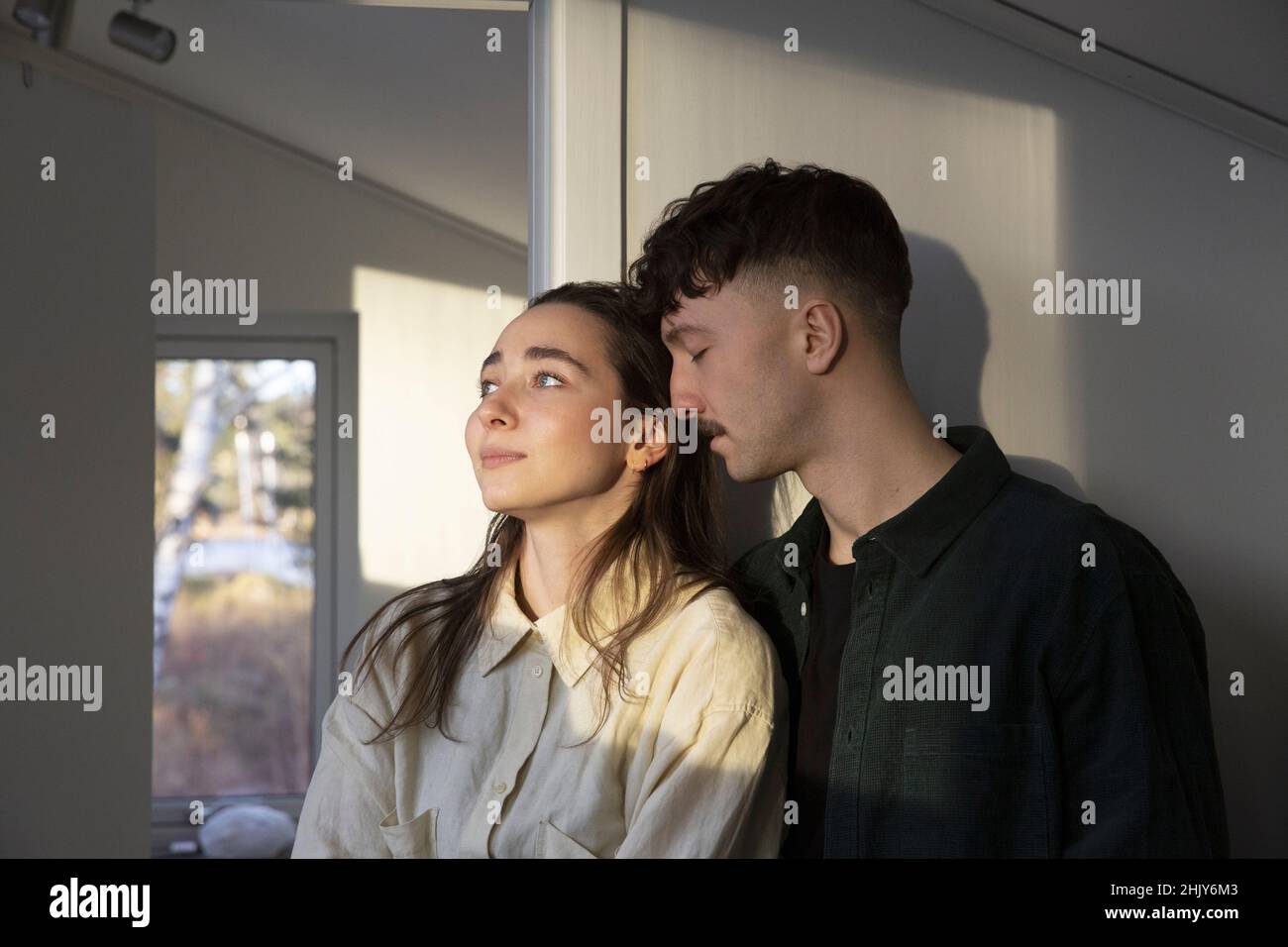 Femme qui regarde loin chez elle par un ami affectueux Banque D'Images