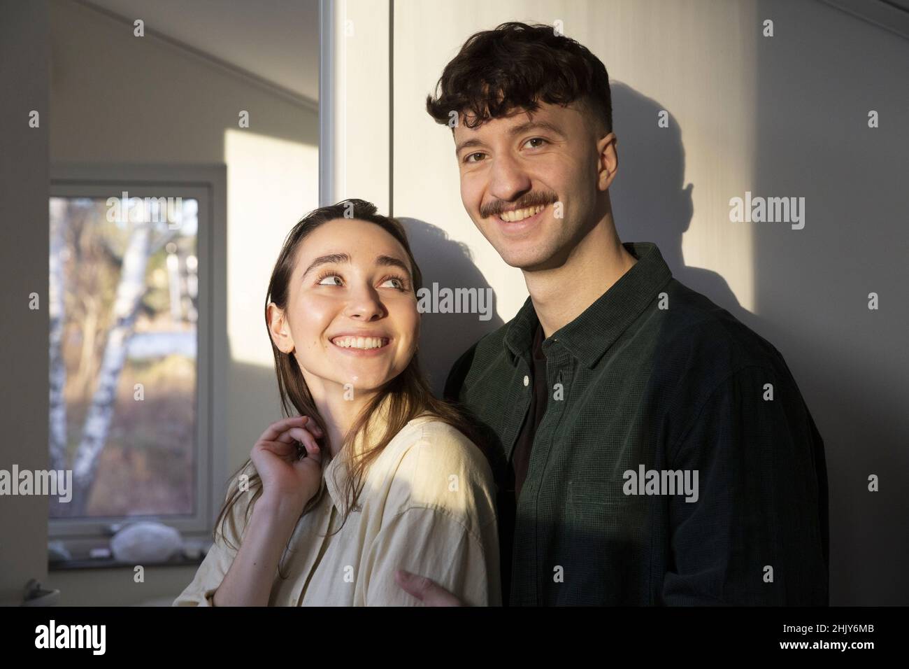 Portrait d'un homme souriant debout avec une petite amie à la maison Banque D'Images