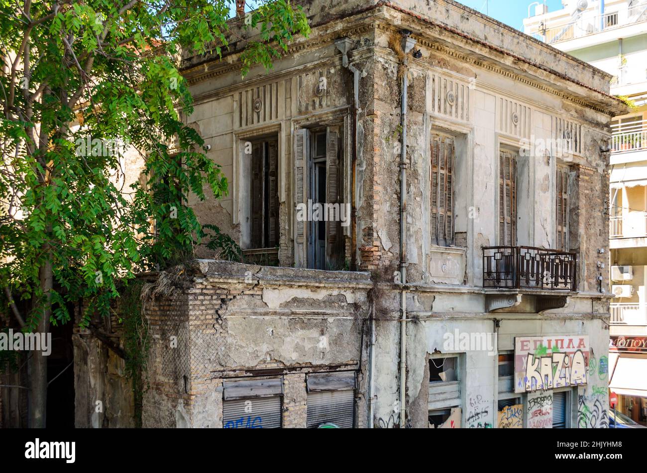 Ancienne maison néoclassique à deux étages en délabré dans le centre-ville de Patras, en Grèce, le jour du soleil. Résidence abandonnée avec grandes fenêtres, cour et balcon. Banque D'Images