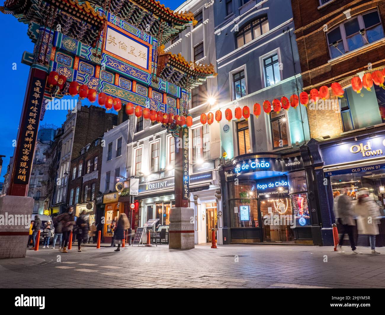 Dragon Gate, Chinatown, Londres. Vue au crépuscule sur les touristes passant par la porte d'entrée dans le quartier populaire des boutiques et des restaurants du centre de Londres. Banque D'Images