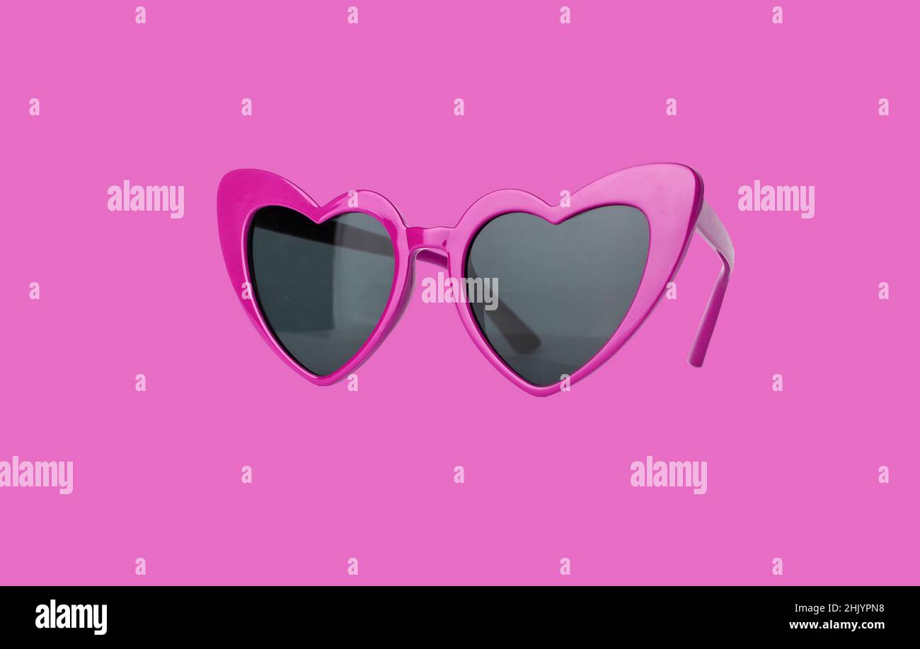 Lunettes de soleil en forme de cœur sur fond rose.Lunettes de soleil pour la Saint-Valentin.Photo de haute qualité Banque D'Images